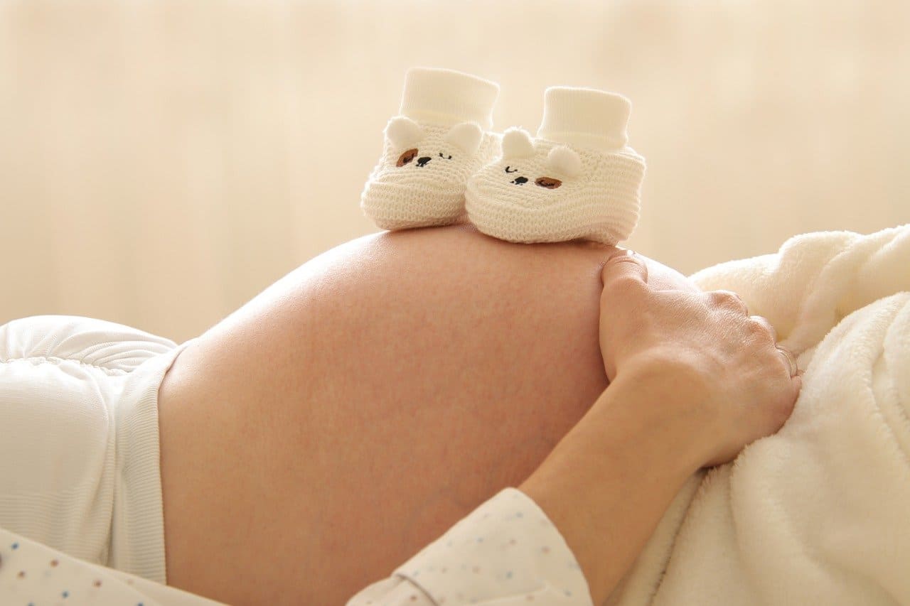 Ventre de grossesse avec des chaussons de bébé